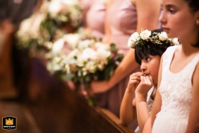 At St. Michael Catholic Church in Livermore, California, two young flower girls stand in the front row at the edge of the bridesmaids, all holding flowers during the ceremony.
